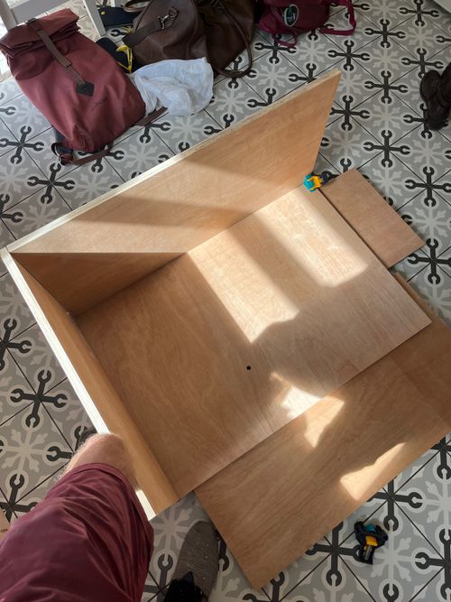 Half a kitchen cabinet. A small clamp holds sun-bathed plywood at 90 degrees.