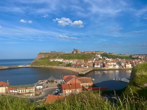 A sunny port between two hills. Whitby abby stands proudly at the opposite site.