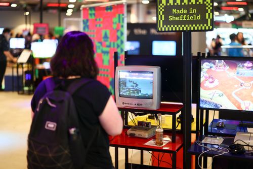 An attendee plays a classic game on an old CRT TV, at the National Videogame Museum. A Made in Sheffield sign indicates these games were made in Sheffield.