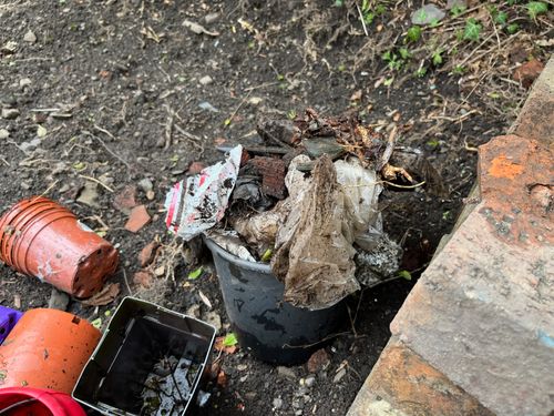 A slightly stomach turning bucket of human detritus: muddy plastics, rusted metal.