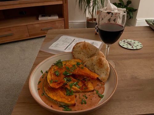 A Malai Kari. A coconut and sauce with spiced, roasted pumpkin on top, and a side of pita (close enough). All garnished with coriander. A glass of red wine and stray shed building instructions which I left out complete the picture.