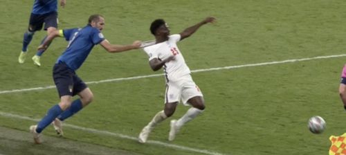 Euro 2020 football final. Italy player Giorgio Chiellini yanks on the shirt neck of England player Bukayo Saka, pulling him back and off his feet.